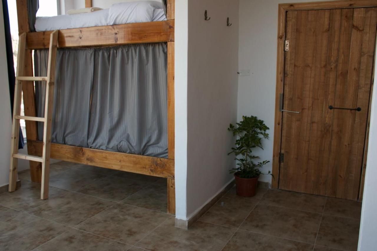 Female dorm with wooden bunks and privacy curtains