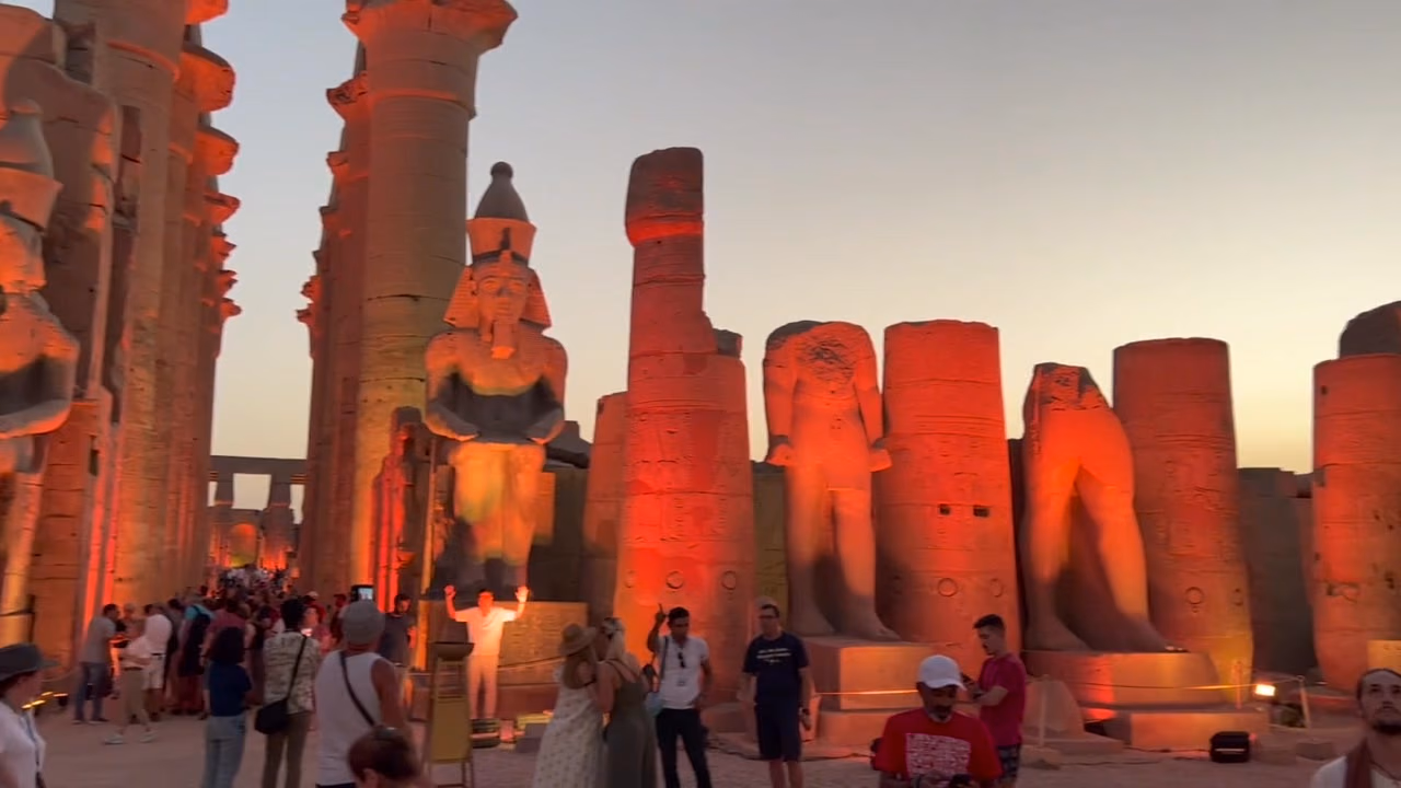 Luxor Temple lit at dusk, the colossi of Ramses II in gold