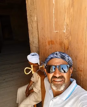 Rami in a headscarf at a wooden door