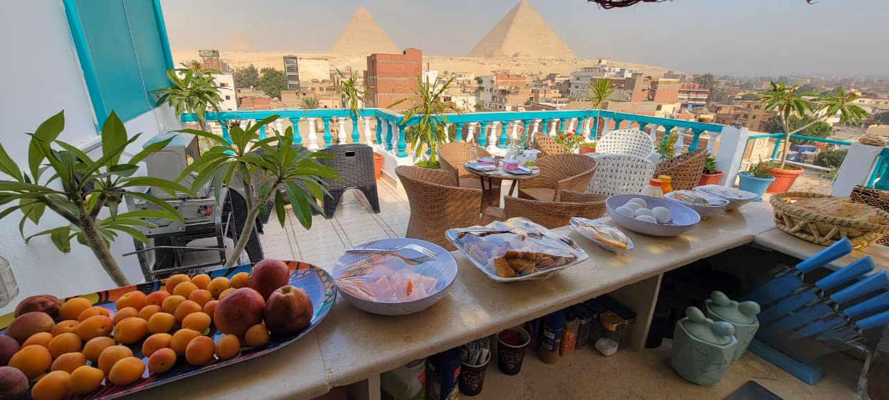 Breakfast laid out on the rooftop with the pyramids behind