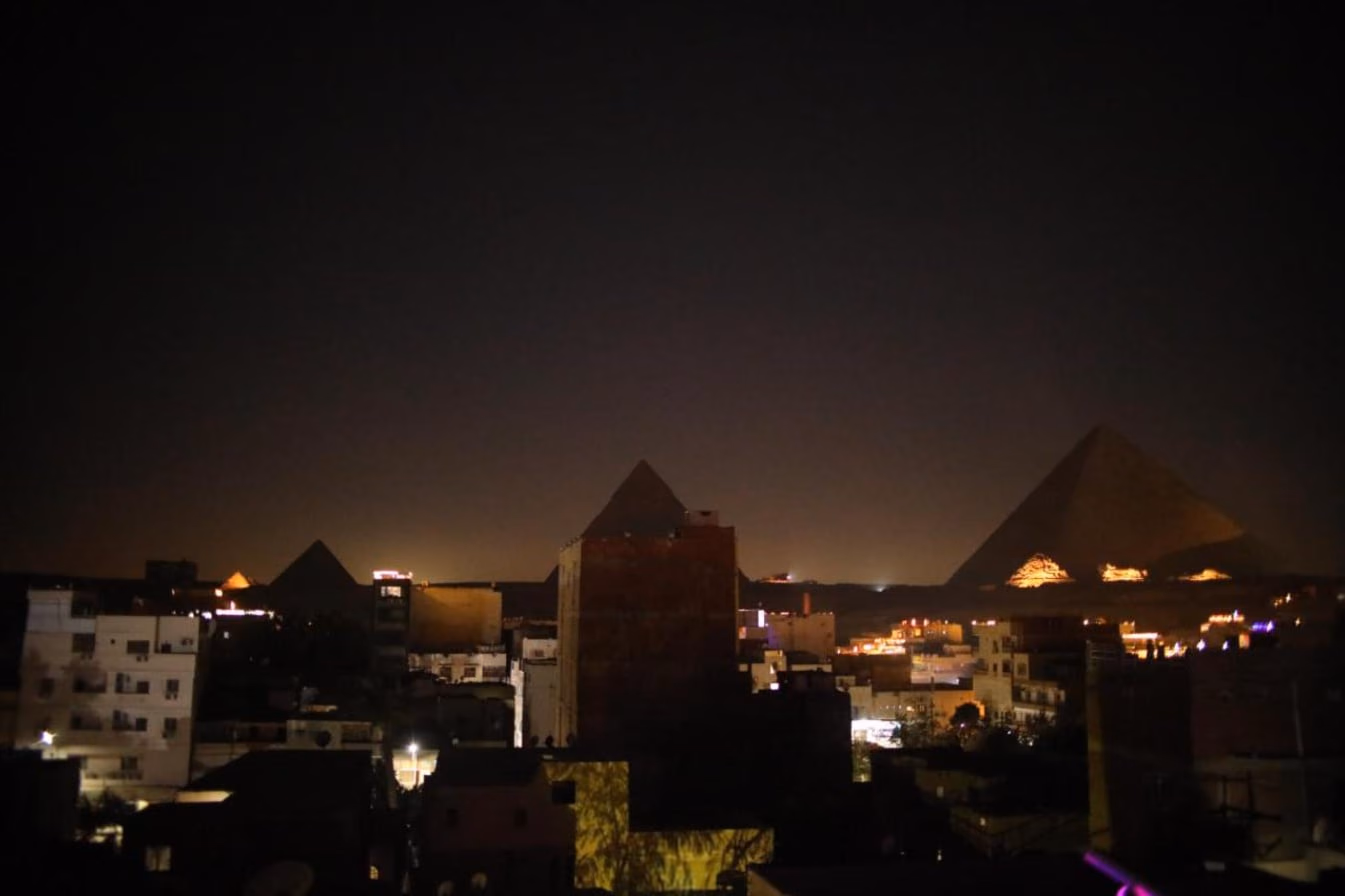 The pyramids lit for the sound and light show, seen from the rooftop at night
