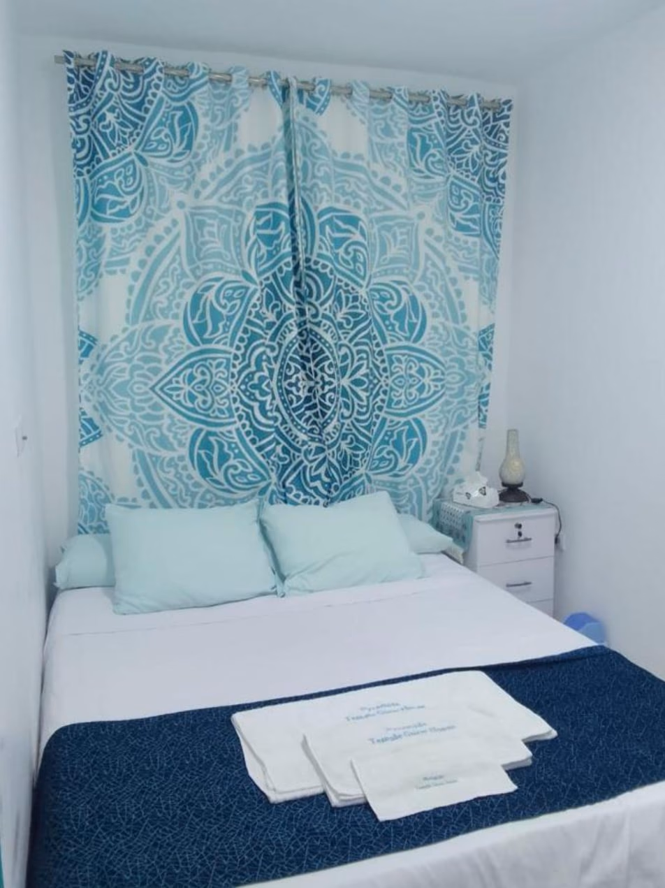 Deluxe Queen Room bed with a mandala curtain and fresh towels