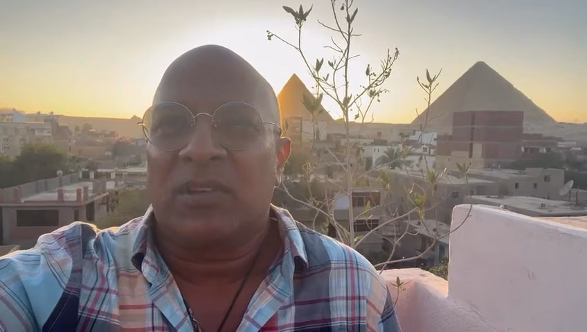 A guest speaking on the guest-house rooftop at sunset
